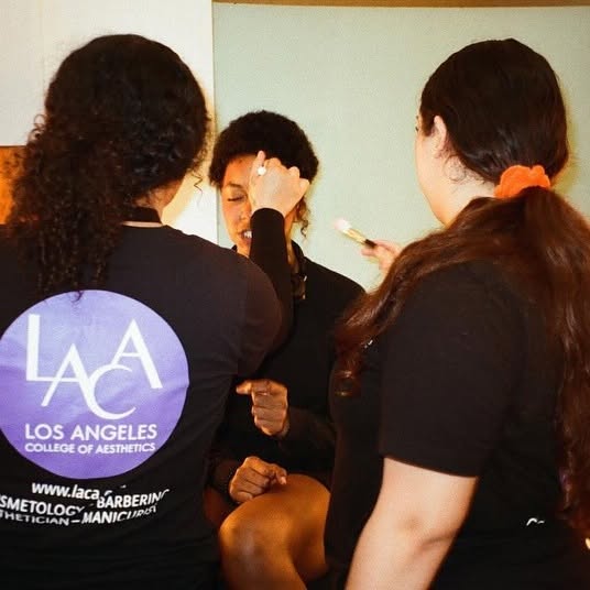 Students applying makeup on someone